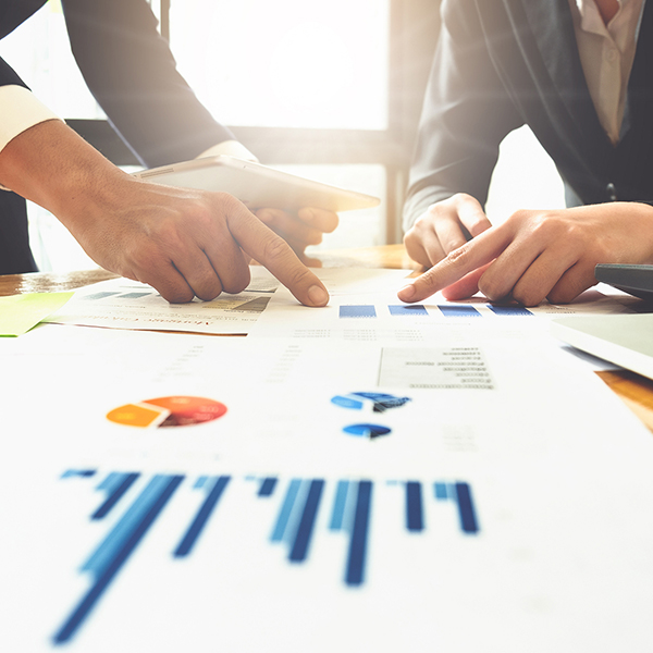 Close up of business man hand pointing at business document on financial paper on wooden desk during discussion at meeting. Group support concept.